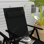 Black padded folding garden chair with headrest and armrests, outdoors on a patio