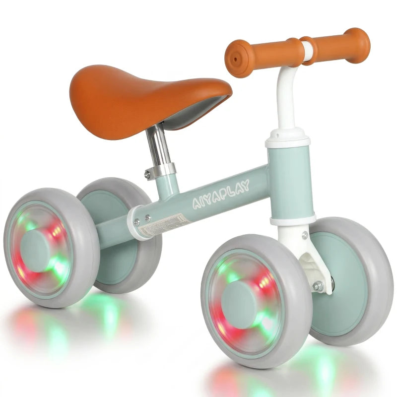 Light-up toddler balance bike with orange seat and green frame, illuminated wheels