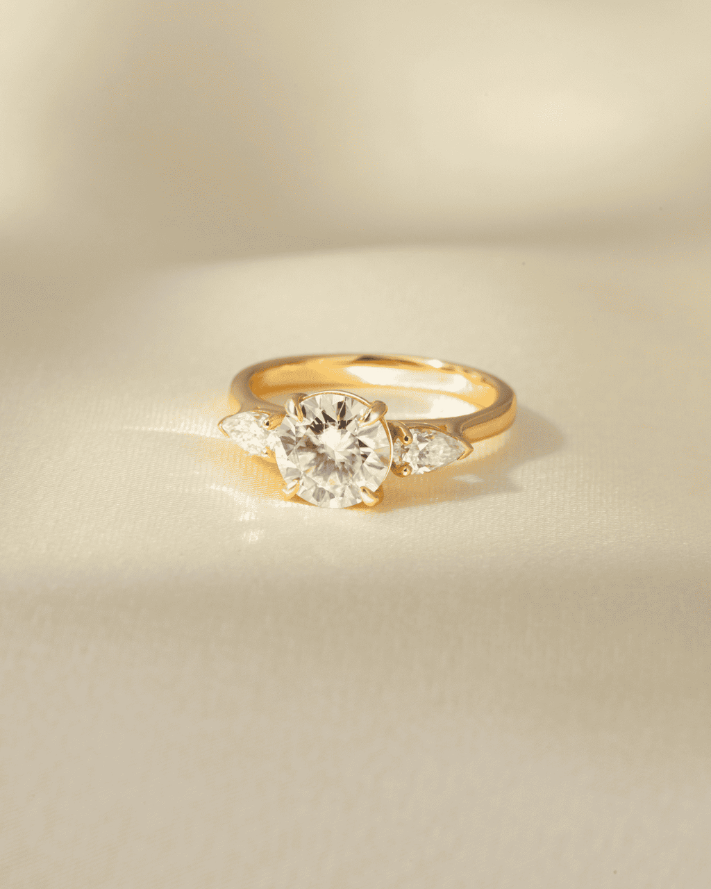 Round moissanite three-stone engagement ring in gold vermeil, top view