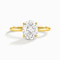 Oval solitaire moissanite ring with gold-tone band and four-prong setting