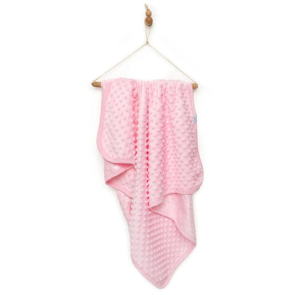Pink baby fleece blanket with raised dot texture, draped over hanger stand.