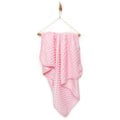 Pink baby fleece blanket with raised dot texture, draped over hanger stand.