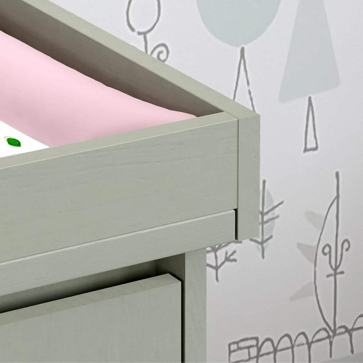 Close-up of grey changing unit rail and drawer opening edge