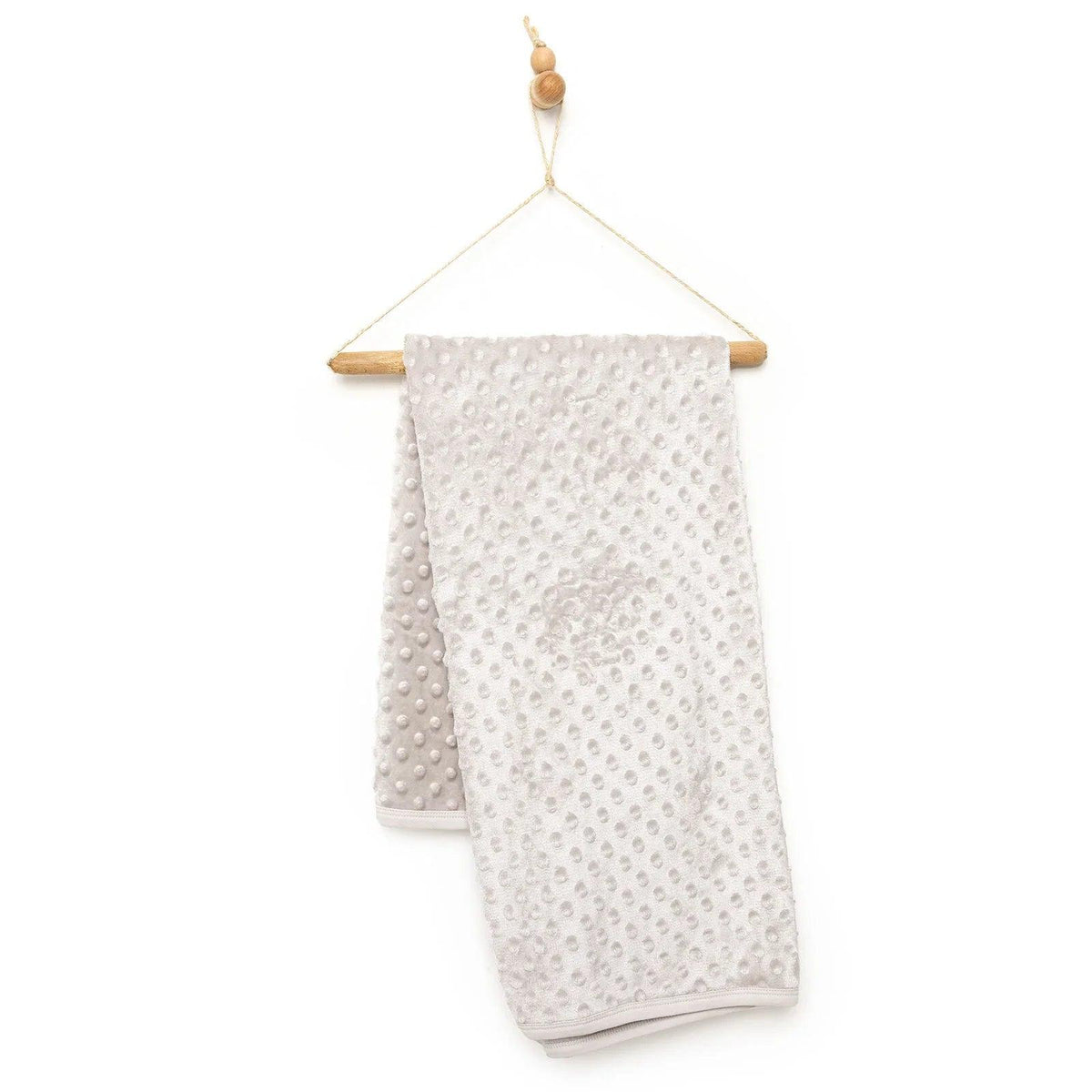 Beige fleece baby blanket with textured dot pattern and folded edge