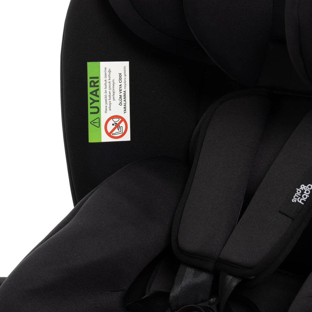 Black car seat interior with green safety label on fabric