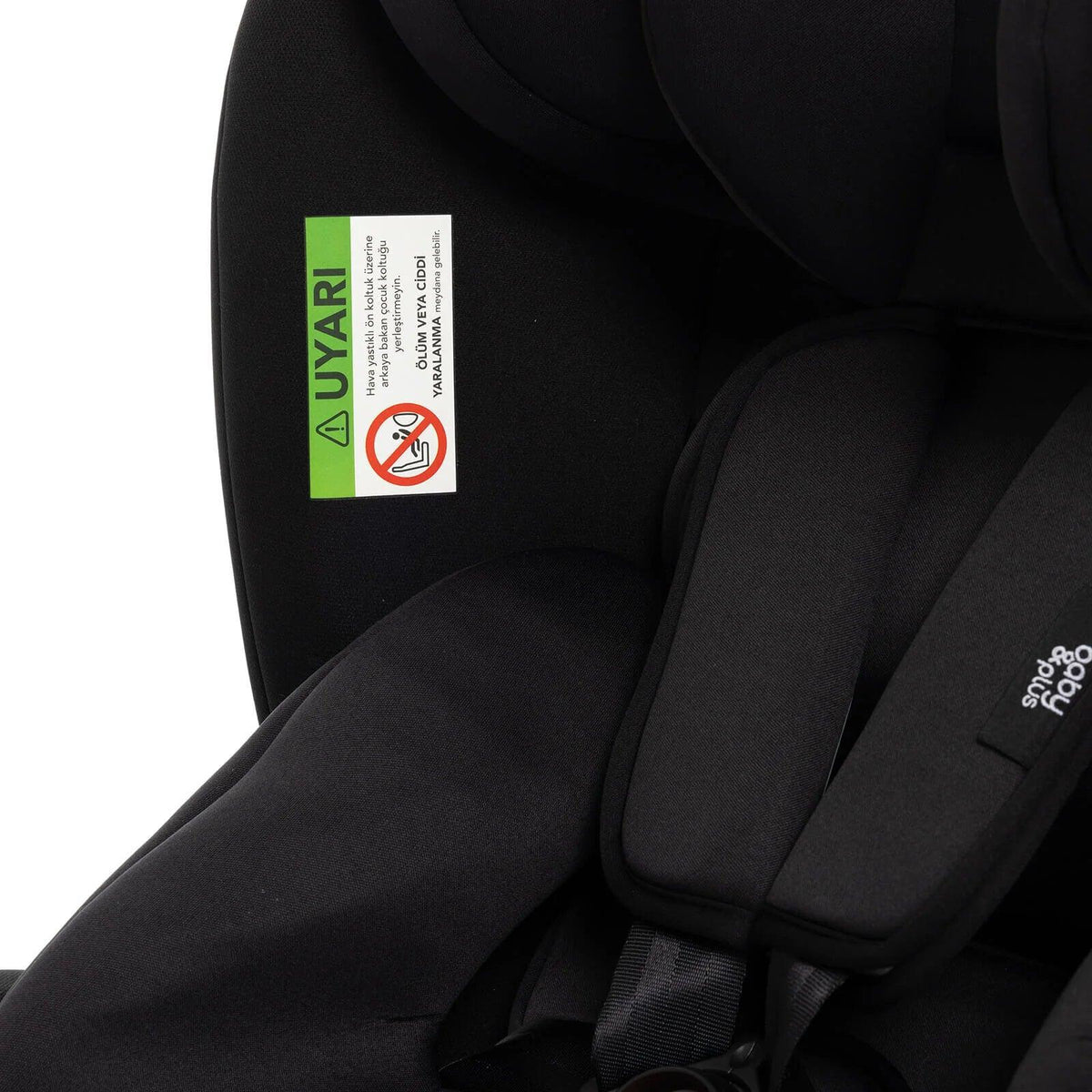 Black car seat interior with green safety label on fabric