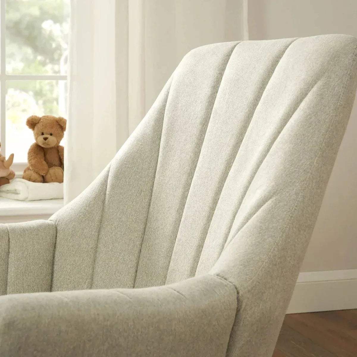 Beige rocking chair close-up showing padded back with vertical channel stitching