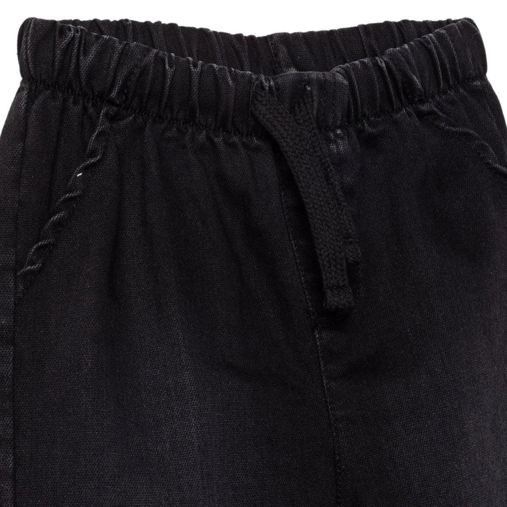 Black denim trousers close-up: elastic waistband and stitched front