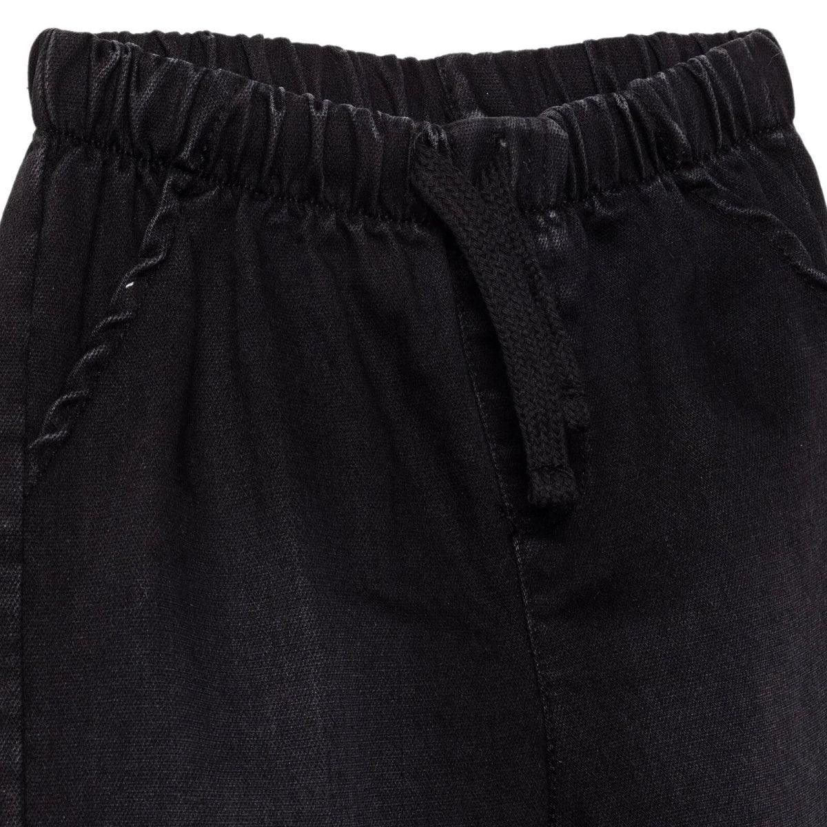 Black denim trousers close-up: elastic waistband and stitched front