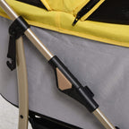 Yellow pet stroller frame close-up with black safety latch and support bar