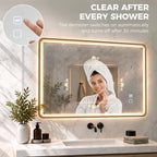 Gold-tone rectangle LED bathroom mirror with anti-fog window and steam-clearing indicator.