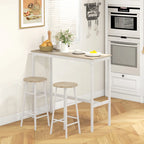 White bar table with two round light oak-tone stools in a kitchen with appliances.
