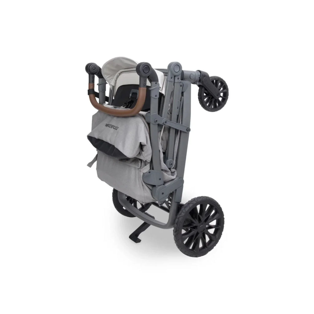 Grey stroller wagon side view with canopy, harness straps, and large wheels