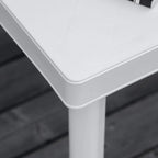 White plastic outdoor table corner with rounded edge and sturdy leg