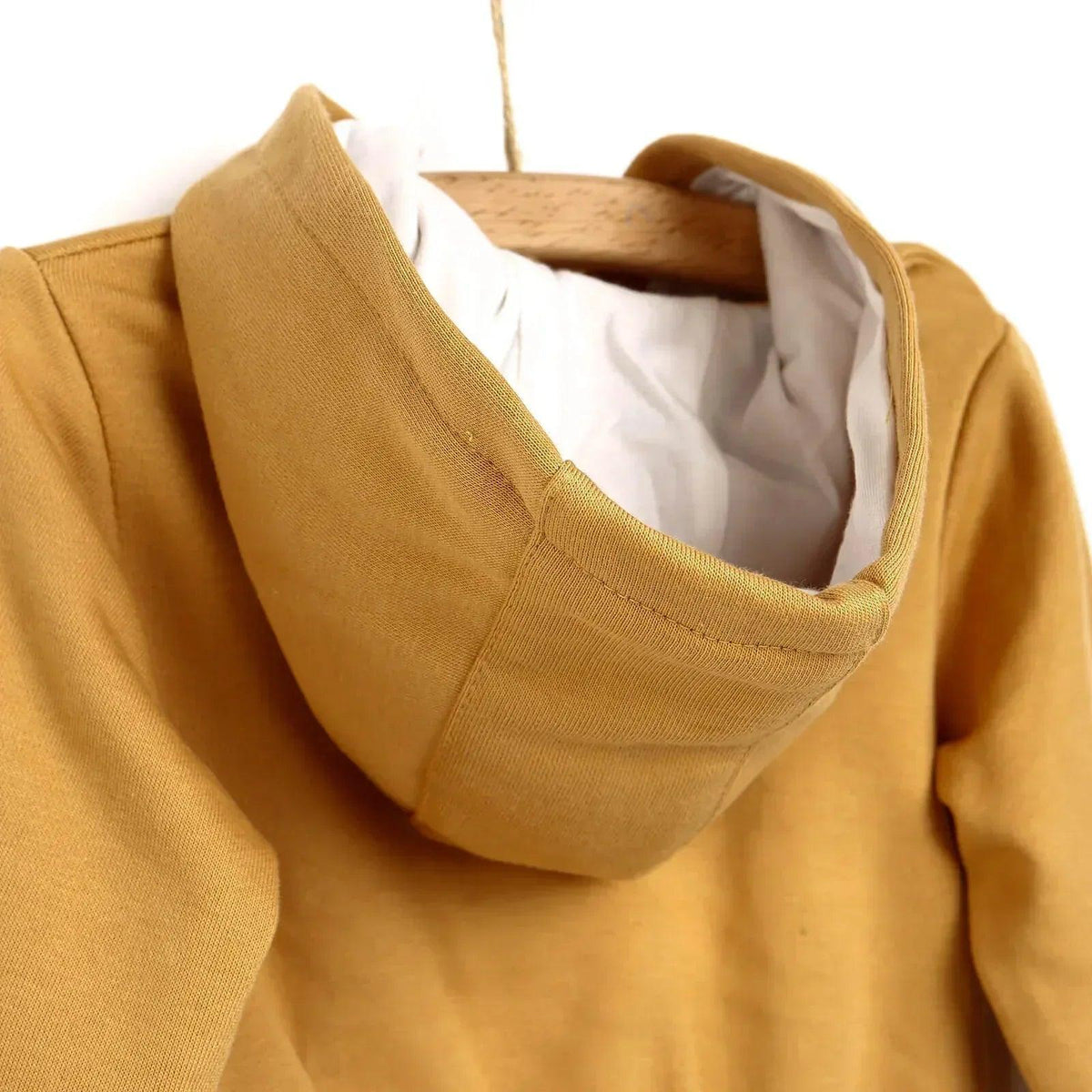 Baby cardigan hood close-up with ribbed trim and white inner lining in cinnamon brown
