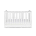 White cot bed with vertical slats and front drawer storage