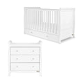 White wooden baby cot with vertical slats and drawer base, angled view