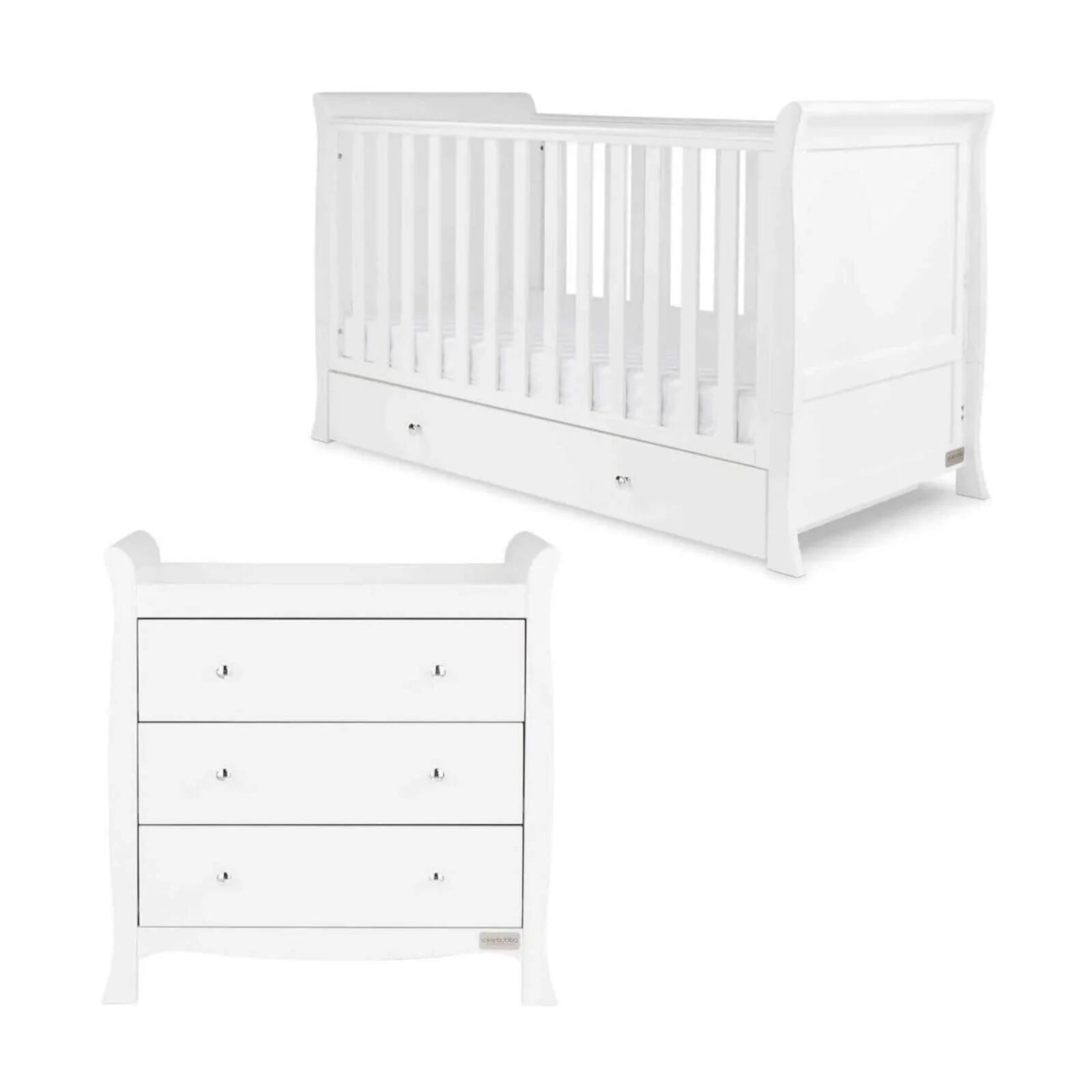 White wooden baby cot with vertical slats and drawer base, angled view