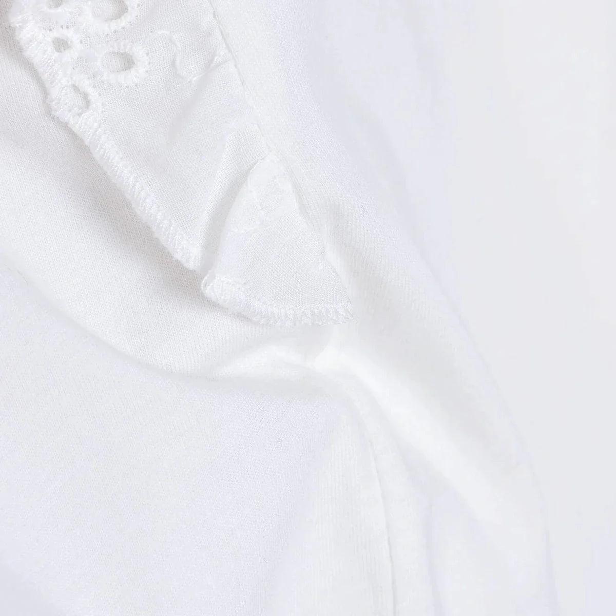 Off-white ruffled sleeve edge with subtle eyelet embroidery.