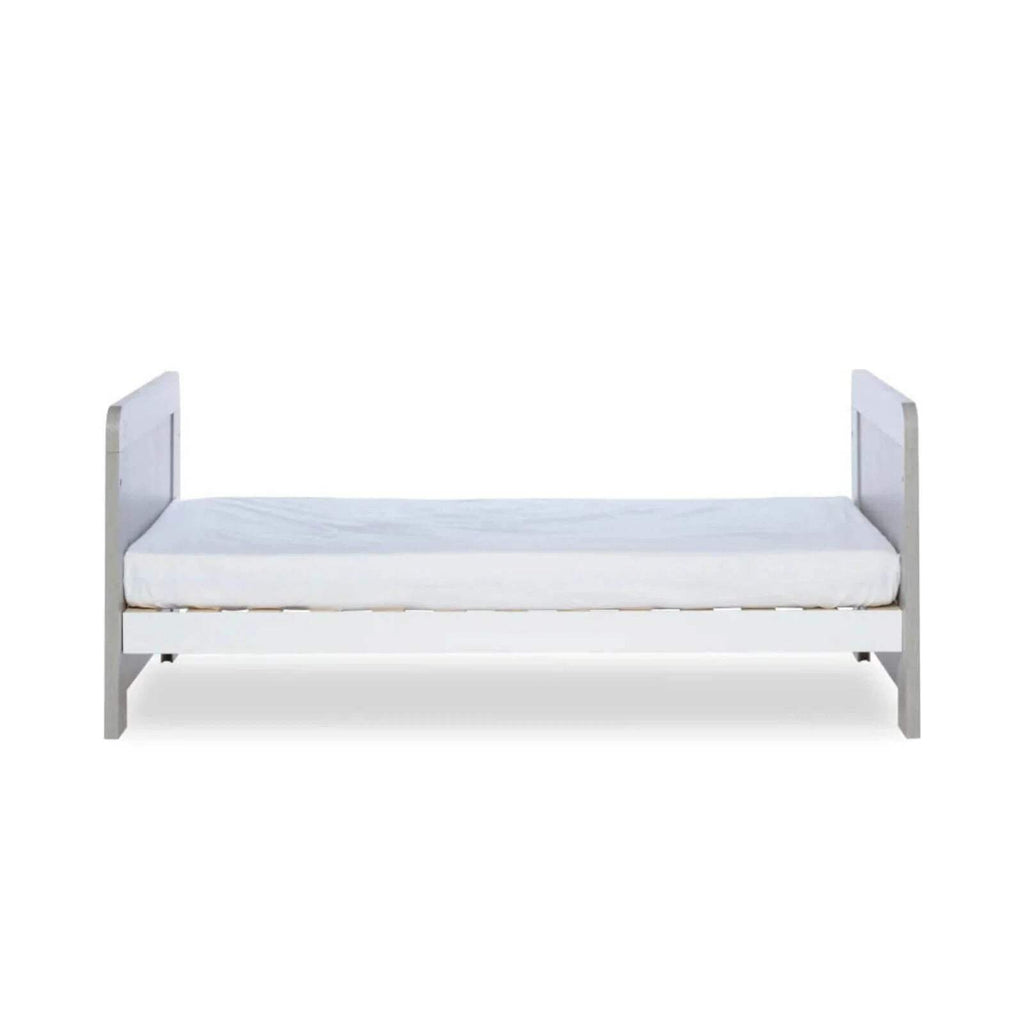 Ash grey cot bed with light mattress base and white protective side rails