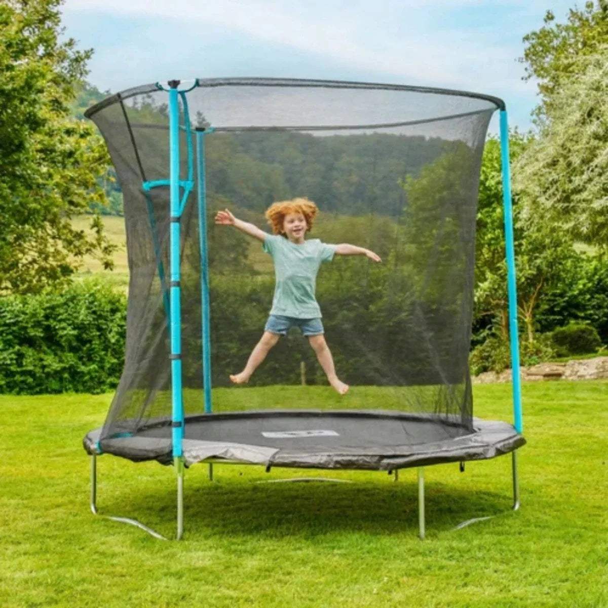 Round trampoline with black mesh safety net and blue support poles, outdoor yard view