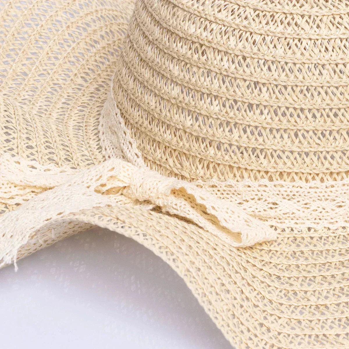 Close-up of ecru straw hat crown stitching and lace-like ribbon trim