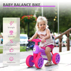 Purple and pink baby balance bike with four wheels and padded seat for toddlers