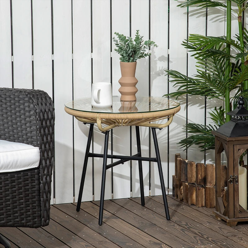 Round rattan side table with clear tempered glass top and black metal legs