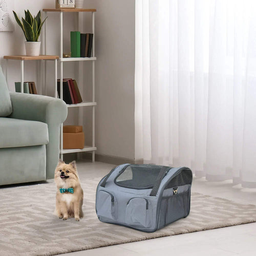 Grey portable pet carrier bag with mesh panels and front zip door, on floor indoors