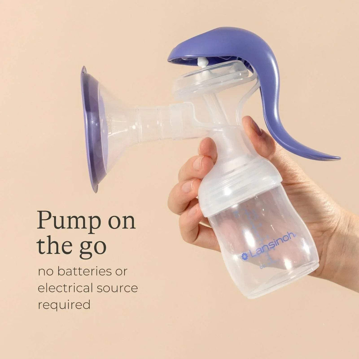Lansinoh manual breast pump held in hand with clear bottle and purple lever