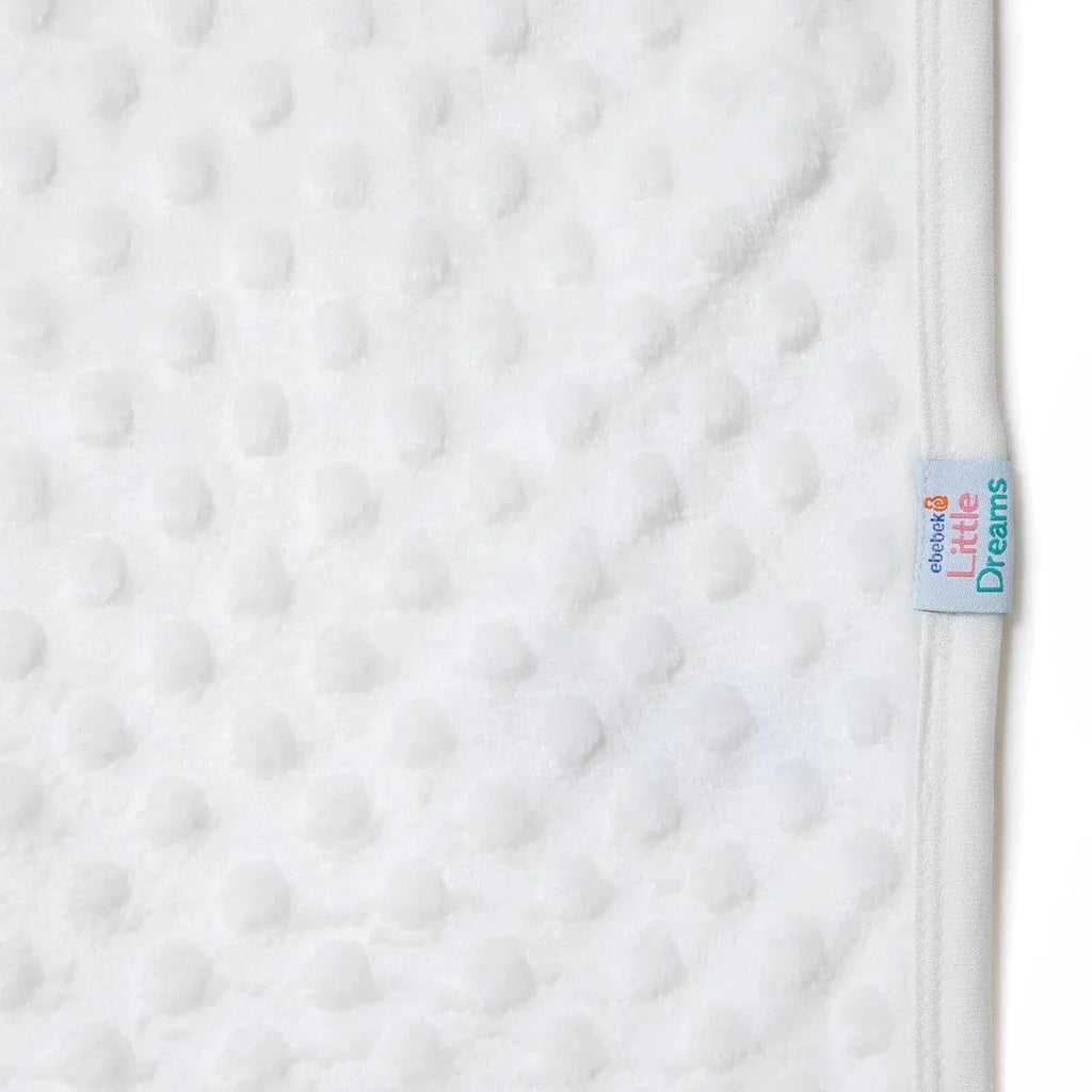 Ecru fleece baby blanket edge close-up with “Little Dreams” label and seam stitch