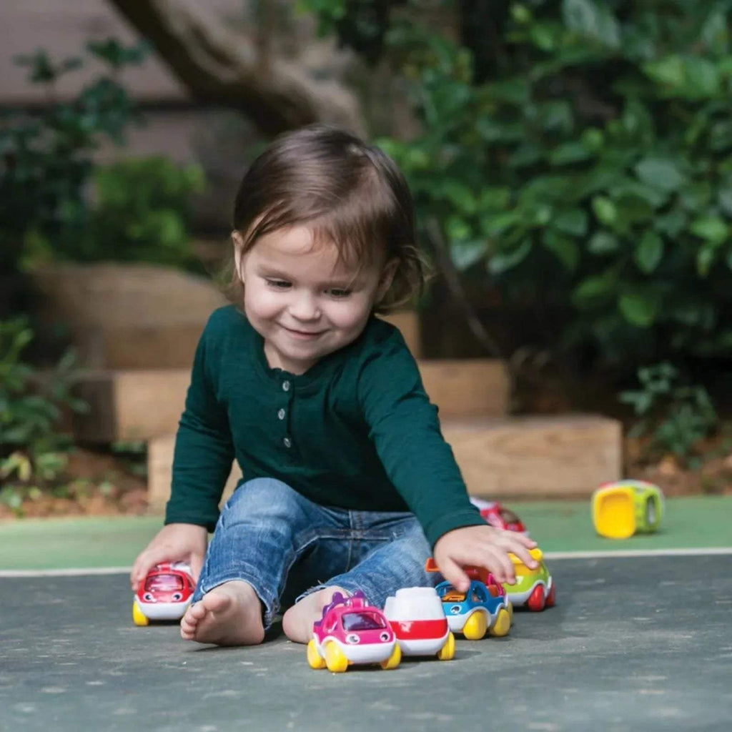 Assorted mini toy cars in red, purple, green, and yellow with smiling faces