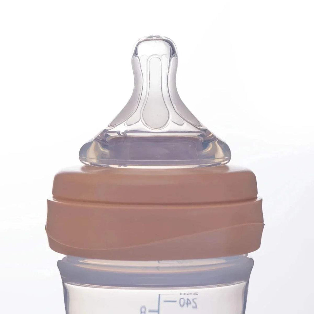 Close-up of Mooma feeding bottle nipple and clear cap with old rose collar