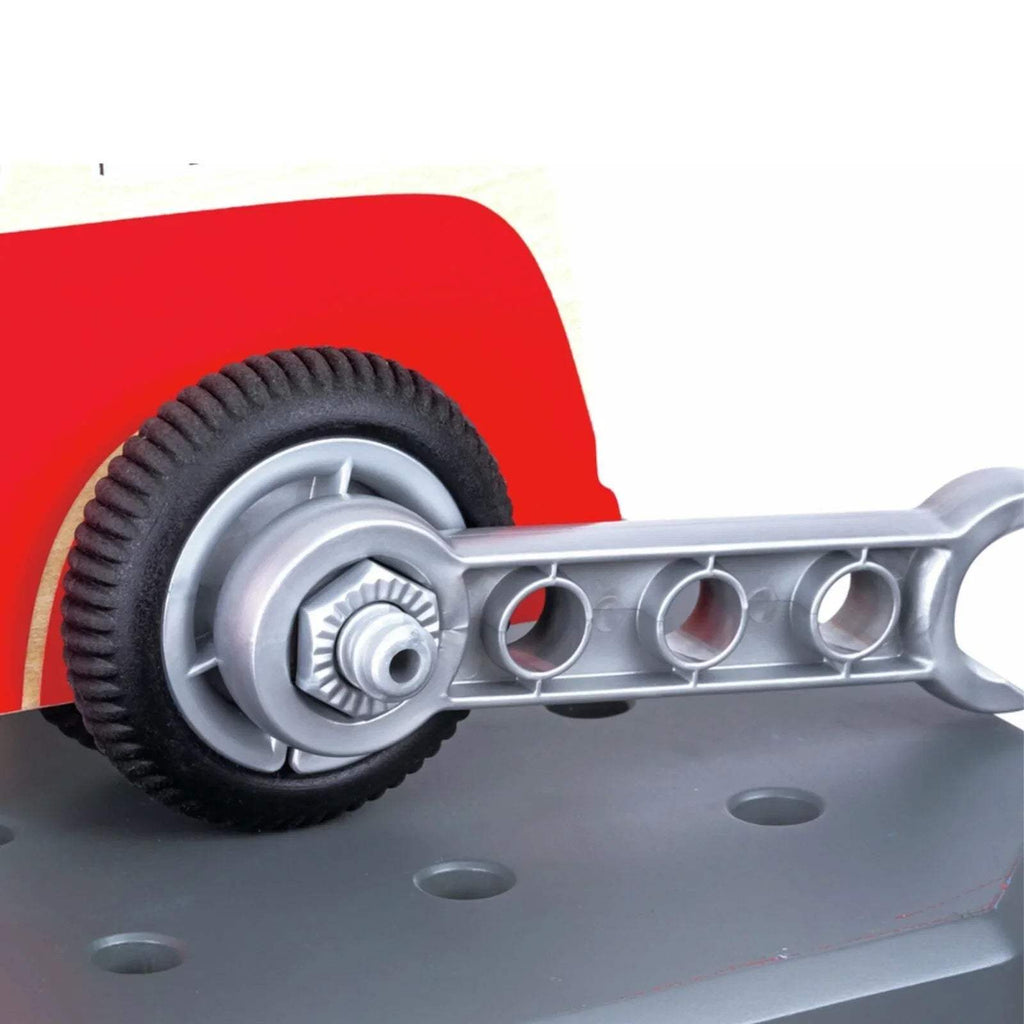 Toy red car with gray wheels and gray tool arm on workbench surface