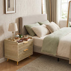 Natural wood bedside table with two drawers and gold metal legs beside a sofa