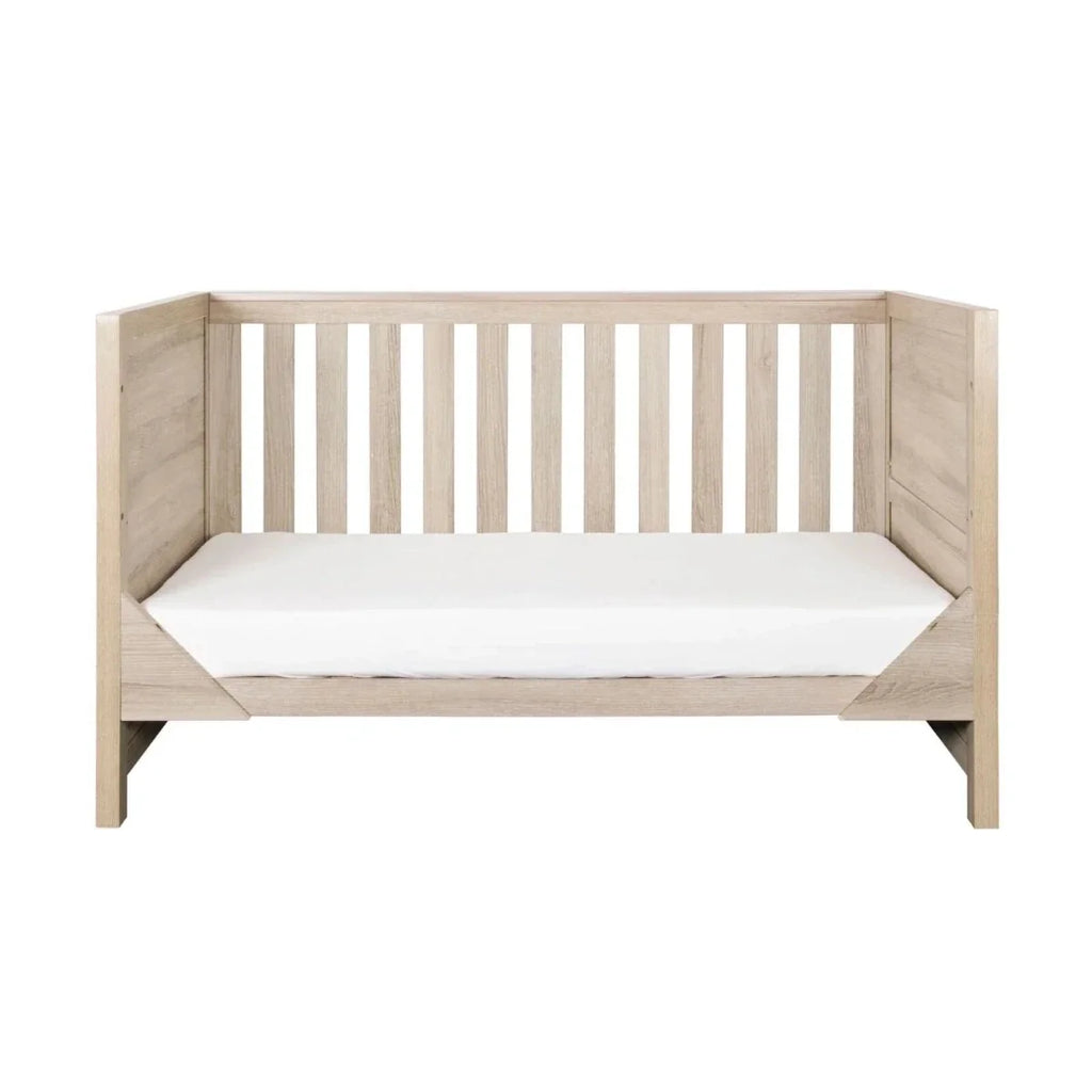 Oak baby cot with slatted sides and white mattress