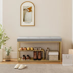 Grey tufted shoe storage bench with open gold-toned steel shelves and shoe display