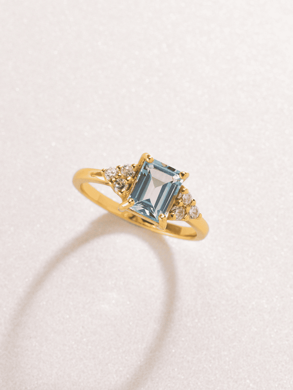 Gold vermeil emerald-cut blue topaz ring with clustered round sparkle accents