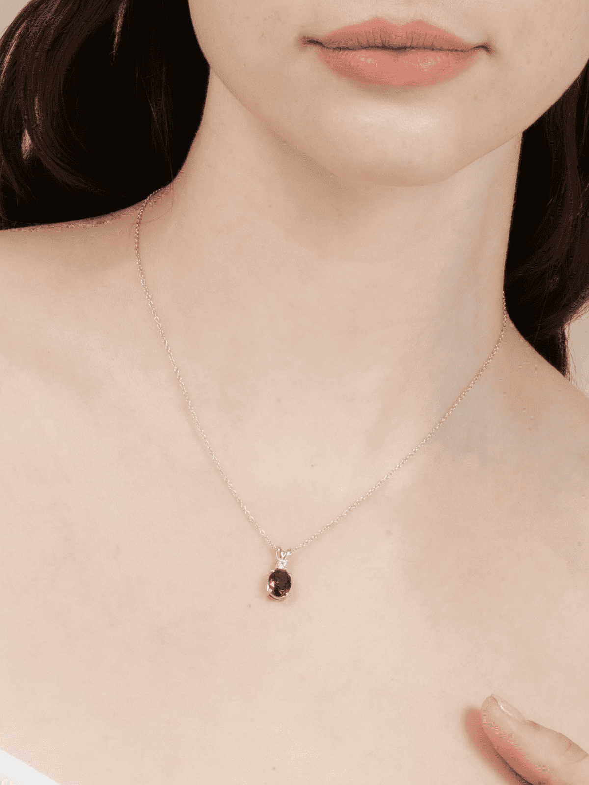 Sterling silver necklace with small red gemstone pendant on fine chain