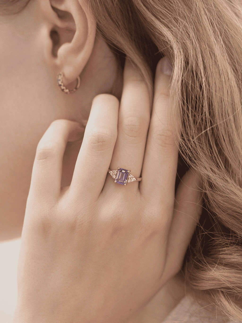 Lavender emerald-cut ring in gold vermeil on finger, square center stone with halo stones