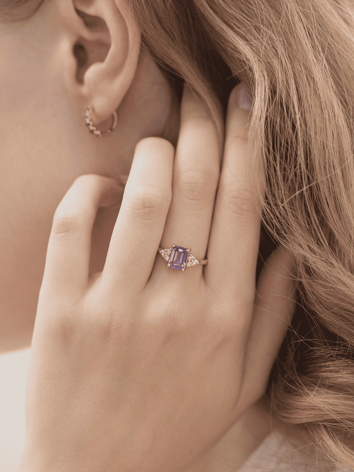 Lavender emerald-cut ring in gold vermeil on finger, square center stone with halo stones