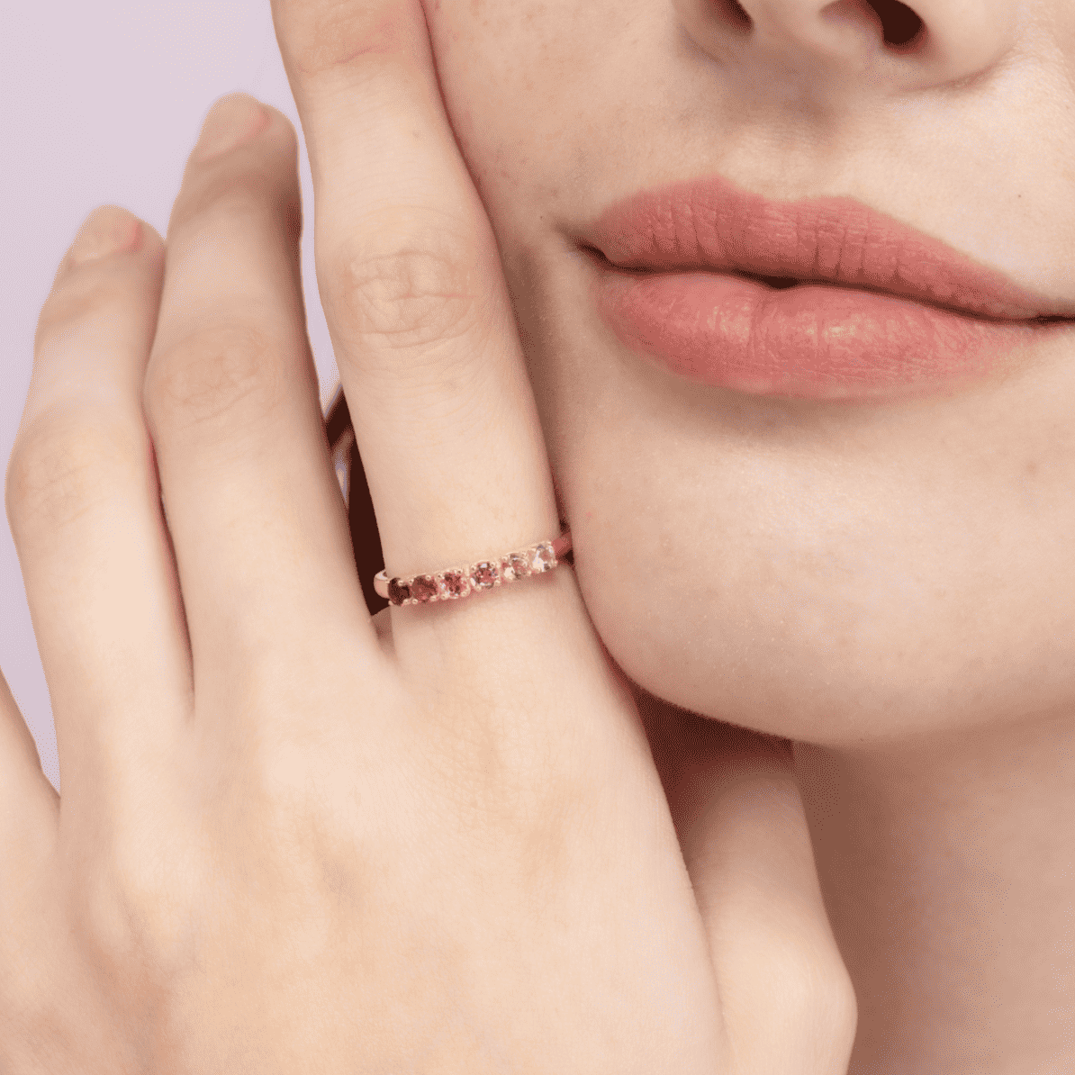 Silver eternity band with pink tourmaline stones on fingertip