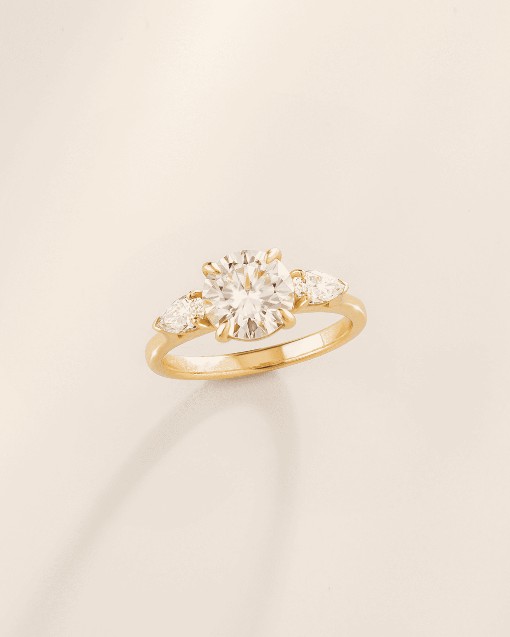Gold vermeil three-stone engagement ring with round center moissanite and side stones