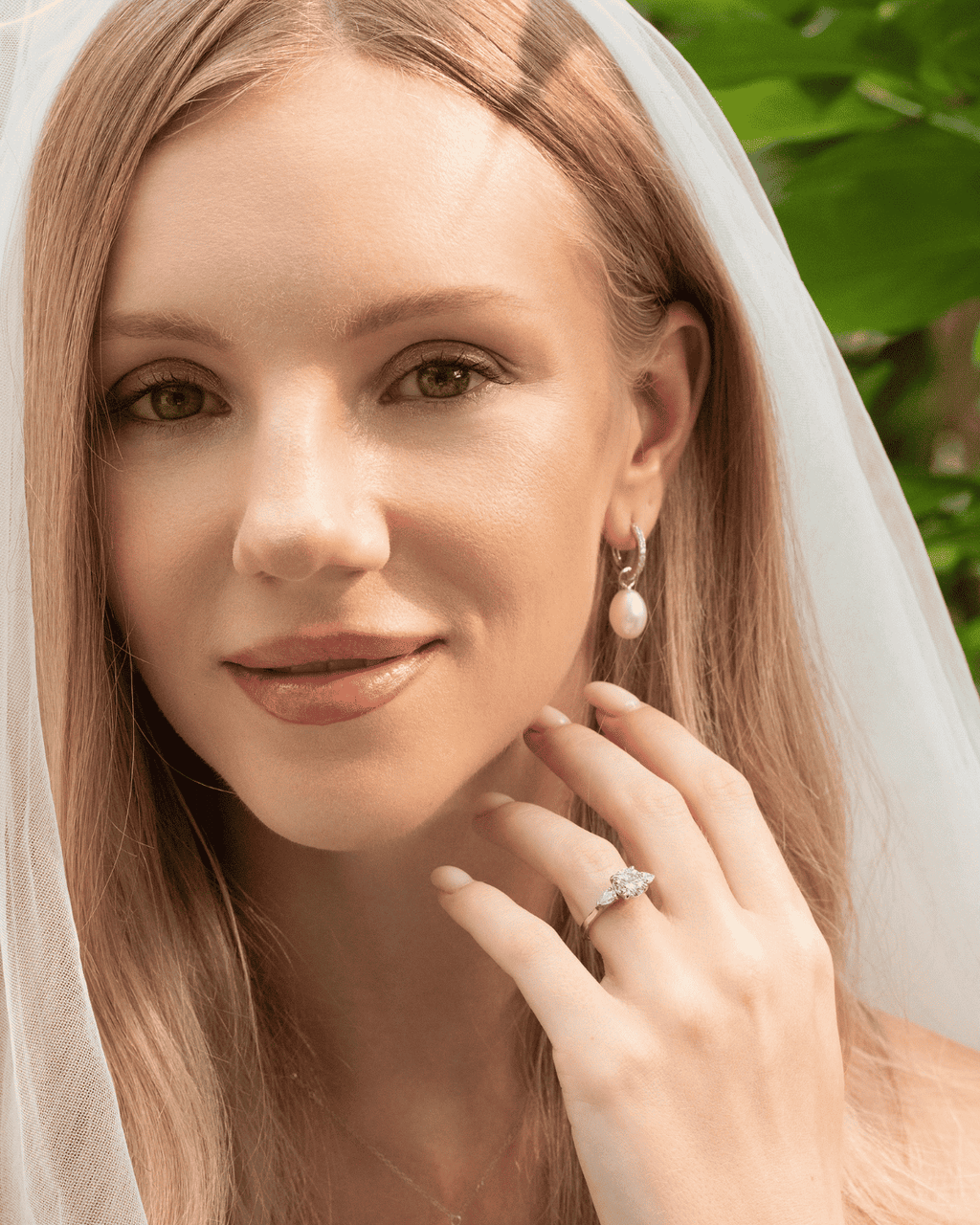 Woman wearing a sterling silver three-stone moissanite ring with round center stone