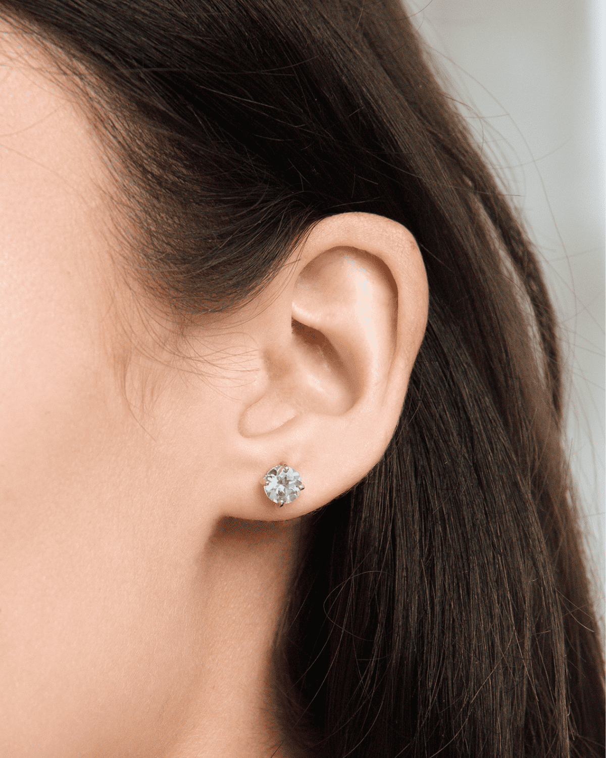 Sterling silver blue topaz stud earrings on ear