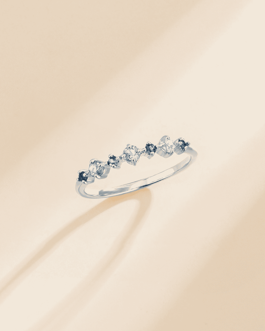Sterling silver half eternity ring with light-blue oval gemstones, angled view