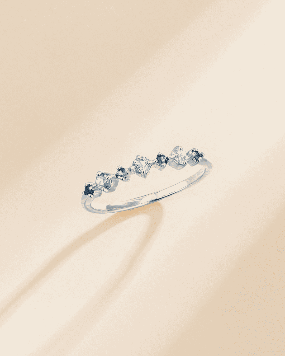 Sterling silver half eternity ring with light-blue oval gemstones, angled view
