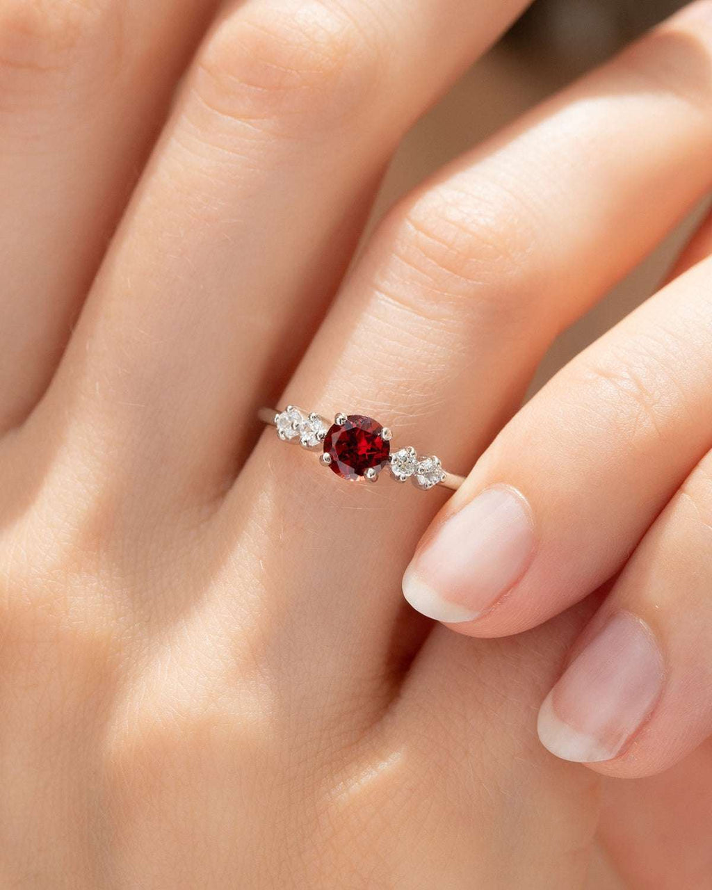 Red round gemstone ring with four small clear stones on sterling silver band