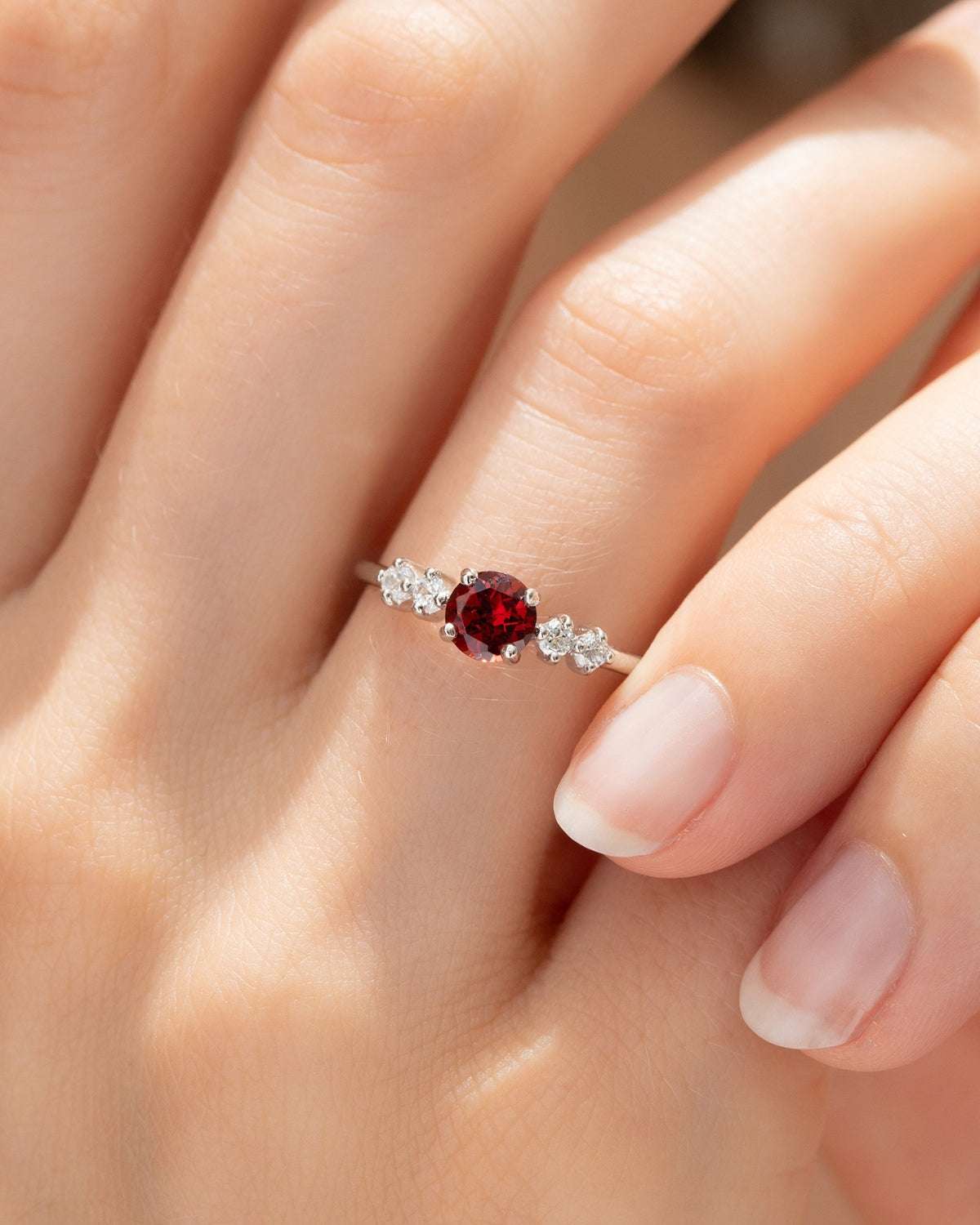 Red round gemstone ring with four small clear stones on sterling silver band