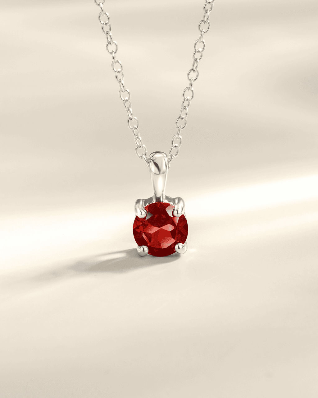 Sterling silver solitaire pendant necklace with red faceted round gemstone